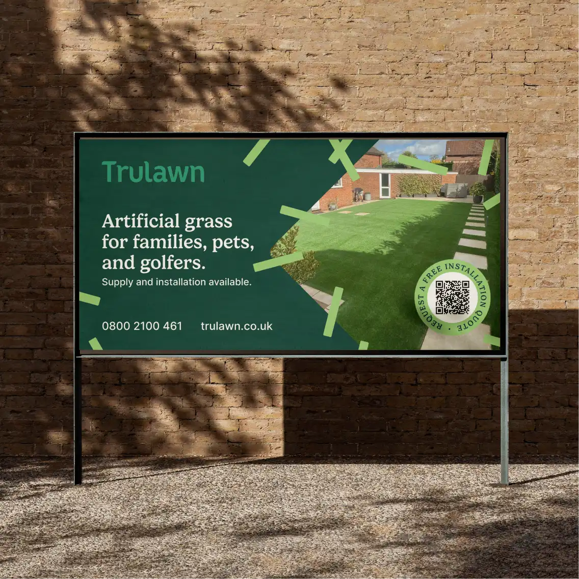 An advertising board in front of a brick wall 